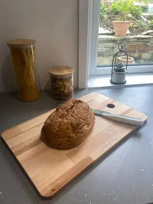 a loaf of bread on a cutting board with a knife at The Porthole in Port Isaac