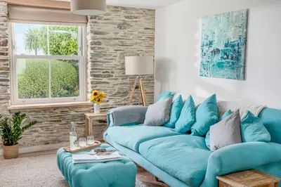 a blue couch in a living room at Characterful cottage near Tintagel and coast path in Treknow