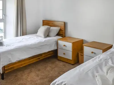 a bedroom with two beds and two night stands at The Hideaway - Spacious 3 Bedroom Apartment in Truro