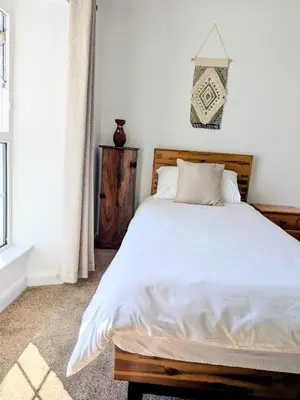 a bedroom with a large bed with white sheets at The Hideaway - Spacious 3 Bedroom Apartment in Truro