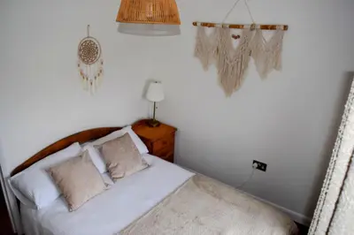 a bedroom with a bed with white sheets and pillows at The Hideaway - Spacious 3 Bedroom Apartment in Truro