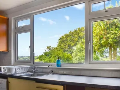 a kitchen with a sink and two windows at The Hideaway - Spacious 3 Bedroom Apartment in Truro
