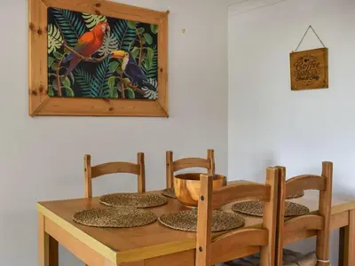 a wooden table with four chairs and a bowl on it at The Hideaway - Spacious 3 Bedroom Apartment in Truro