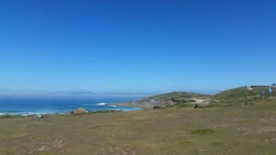 a group of people standing on a hill overlooking the ocean at Headland Hideaway, Fistral Beach Newquay, Cornwall in Newquay