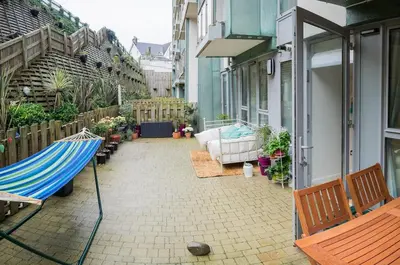 a patio with a hammock on a house at Headland Hideaway, Fistral Beach Newquay, Cornwall in Newquay