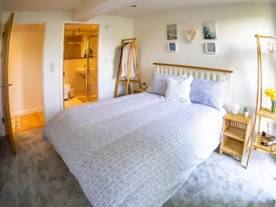 a bedroom with a large bed and a closet at Atlantic Hideaway, Fistral Beach, Newquay Cornwall in Newquay