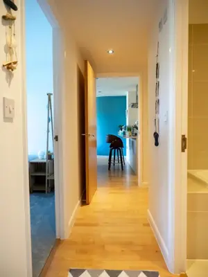 a hallway with a door leading into a room with a table at Atlantic Hideaway, Fistral Beach, Newquay Cornwall in Newquay