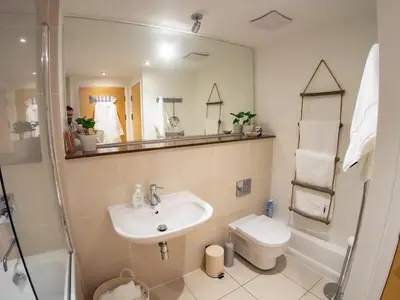 a bathroom with a sink and a toilet and a mirror at Atlantic Hideaway, Fistral Beach, Newquay Cornwall in Newquay