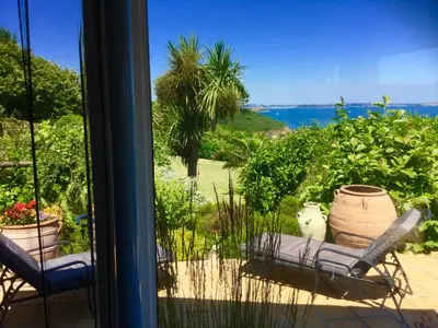 a patio with two chairs and a view of the ocean at Lanteague Cornwall with stunning Sea Views in Gillan