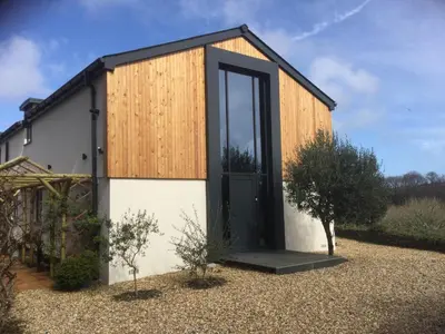 a small house with a black door in a yard at Lanteague Cornwall with stunning Sea Views in Gillan