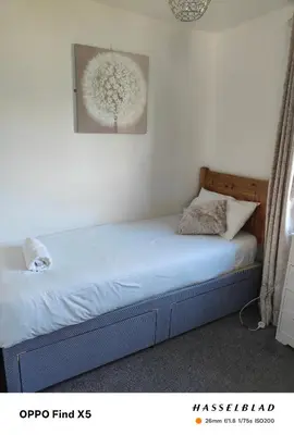 a bed in a bedroom with a picture on the wall at Tolroy manor holiday cottage in Saint Erth