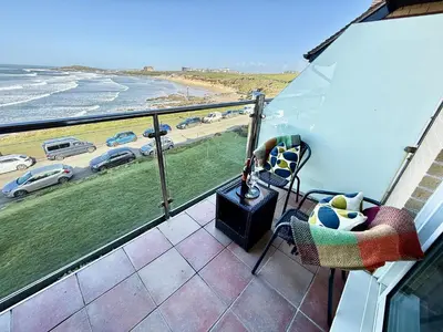 a balcony with a view of the beach and cars at 16 Waters Edge, Atlantic Breezes in Newquay