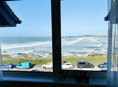 a window with a view of the ocean and cars parked at 16 Waters Edge, Atlantic Breezes in Newquay