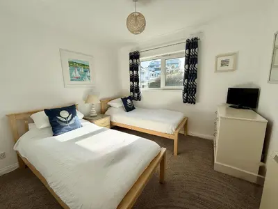 a bedroom with two beds and a tv in it at 16 Waters Edge, Atlantic Breezes in Newquay