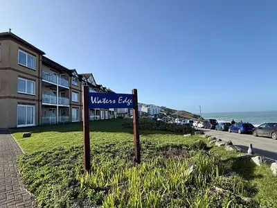 a sign for the westervelt lodge next to the ocean at 16 Waters Edge, Atlantic Breezes in Newquay