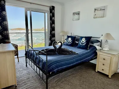 two birds sitting on a bed in a bedroom at 16 Waters Edge, Atlantic Breezes in Newquay