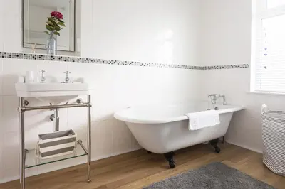 a bathroom with a white tub and a sink at Pendunes - Spectacular views, turquoise sea, love Cornwall in St Ives