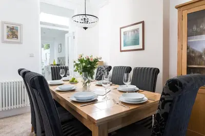a dining room with a wooden table and chairs at Pendunes - Spectacular views, turquoise sea, love Cornwall in St Ives