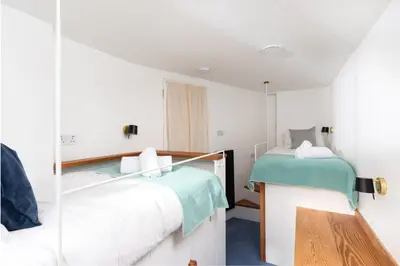 a bedroom with two beds and a mirror at 11 Piazza in St Ives