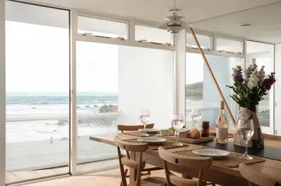 a dining room with a table and a view of the ocean at 11 Piazza in St Ives