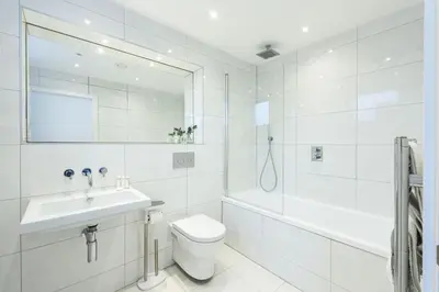 a white bathroom with a sink and a toilet and a tub at 1 Island Reach in Newquay