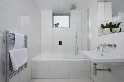 a white bathroom with a tub and a sink at 1 Island Reach in Newquay