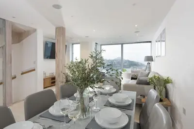 a dining room and living room with a table and chairs at 1 Island Reach in Newquay
