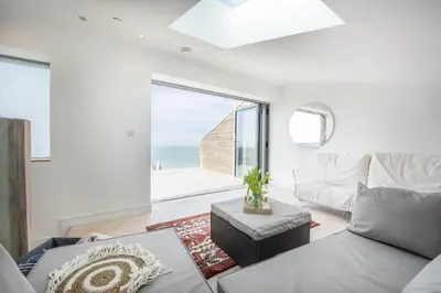 a living room with a couch and a view of the ocean at 1 Island Reach in Newquay