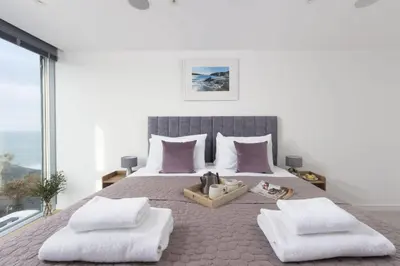 a bedroom with a large bed with purple pillows at 1 Island Reach in Newquay