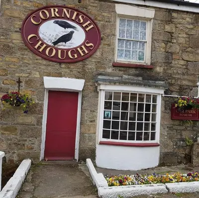 a sign on the side of a building with a window at cornish Choughs Inn in Camborne