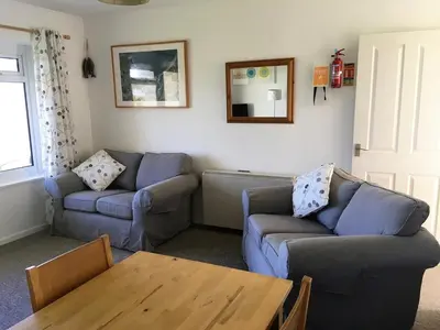 a living room with two couches and a wooden table at Ground Floor Chyreene in Phillack