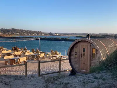 a circular building on the beach with tables and chairs at Ground Floor Chyreene in Phillack