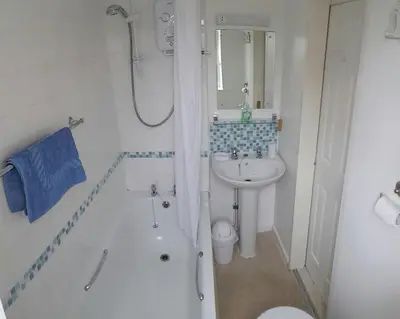a bathroom with a sink and a shower and a toilet at Ground Floor Chyreene in Phillack