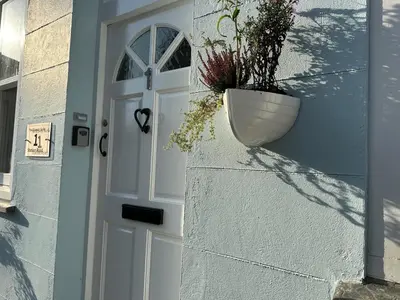 a door with a vase on the side of a house at The Slipway Suite Fowey Harbour & Parking 1 Min in Fowey