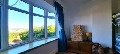 a room with a window with a horse sitting next to it at Ligger View in Perranporth