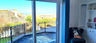 a room with a sliding glass door with a view of a balcony at Ligger View in Perranporth