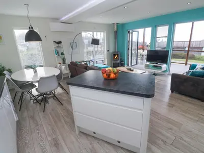 a kitchen and living room with a kitchen island with a bowl of fruit at Hepworth in Redruth