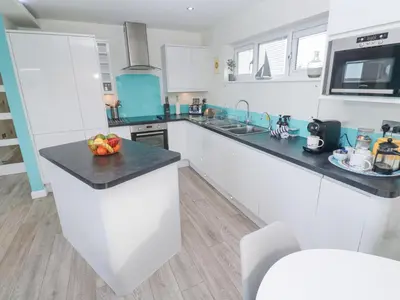a white kitchen with a bowl of fruit on a counter at Hepworth in Redruth