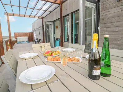 a table with a bottle of wine and a plate of food at Hepworth in Redruth