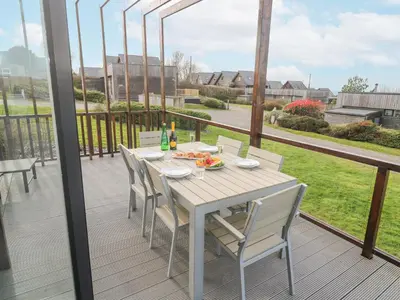 a wooden deck with a table and chairs on it at Hepworth in Redruth