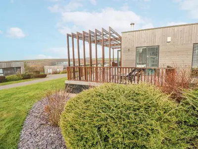 a building with a deck next to a yard at Hepworth in Redruth