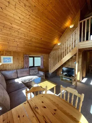 a living room with a couch and a table in a cabin at 3 Bedroom Lodge Lanteglos 21 in Lanteglos