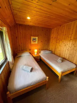 two beds in a room with wooden walls at 3 Bedroom Lodge Lanteglos 21 in Lanteglos