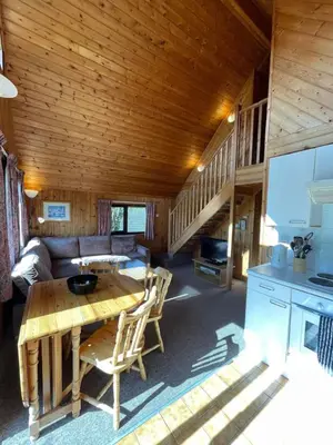 a living room with a table in a cabin at 3 Bedroom Lodge Lanteglos 21 in Lanteglos