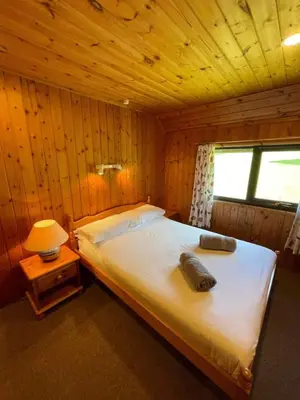 a bedroom with a bed in a wooden cabin at 3 Bedroom Lodge Lanteglos 21 in Lanteglos