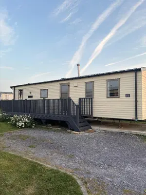 a mobile home with a porch and a deck at Padstow Holiday Base Bright Two Bedroom Lodge at Seven Bays in St Merryn