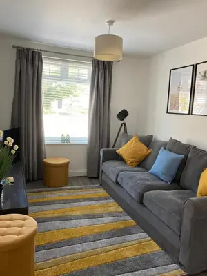 a living room with a gray couch and a window at Newquay Beachcomber, 1 bedroom apartment in Saint Columb Minor