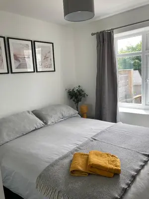 a bedroom with a bed with a yellow towel on it at Newquay Beachcomber, 1 bedroom apartment in Saint Columb Minor