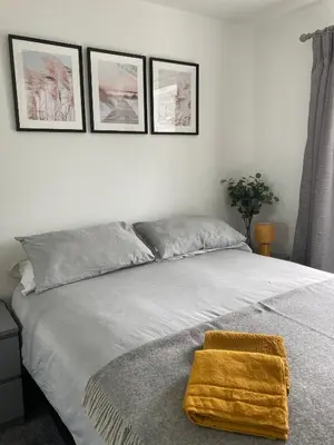 a bedroom with a bed with a gold towel on it at Newquay Beachcomber, 1 bedroom apartment in Saint Columb Minor