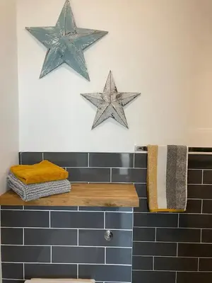 two stars on the wall above a counter in a bathroom at Newquay Beachcomber, 1 bedroom apartment in Saint Columb Minor